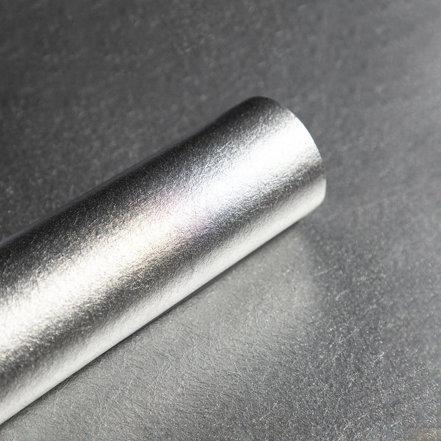 Roll of textured silver wallpaper