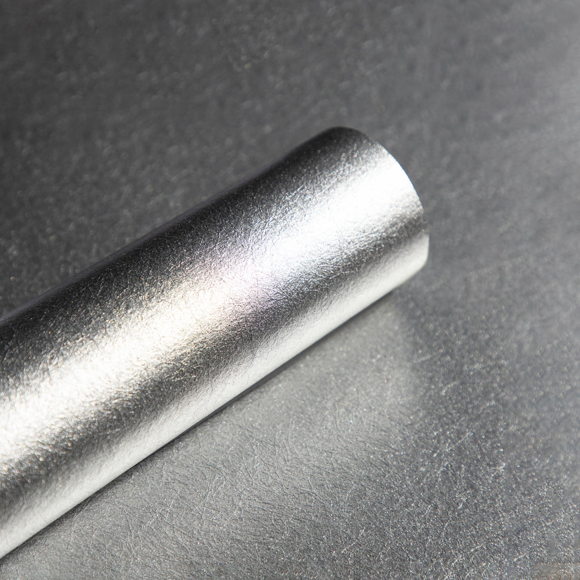 Roll of textured silver wallpaper